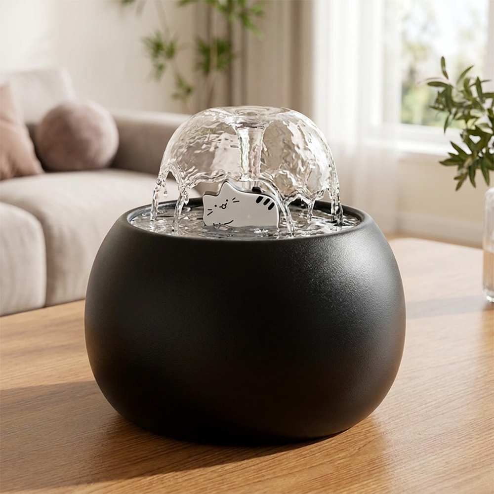 Black ceramic cat fountain with blooming water dome on a wooden table